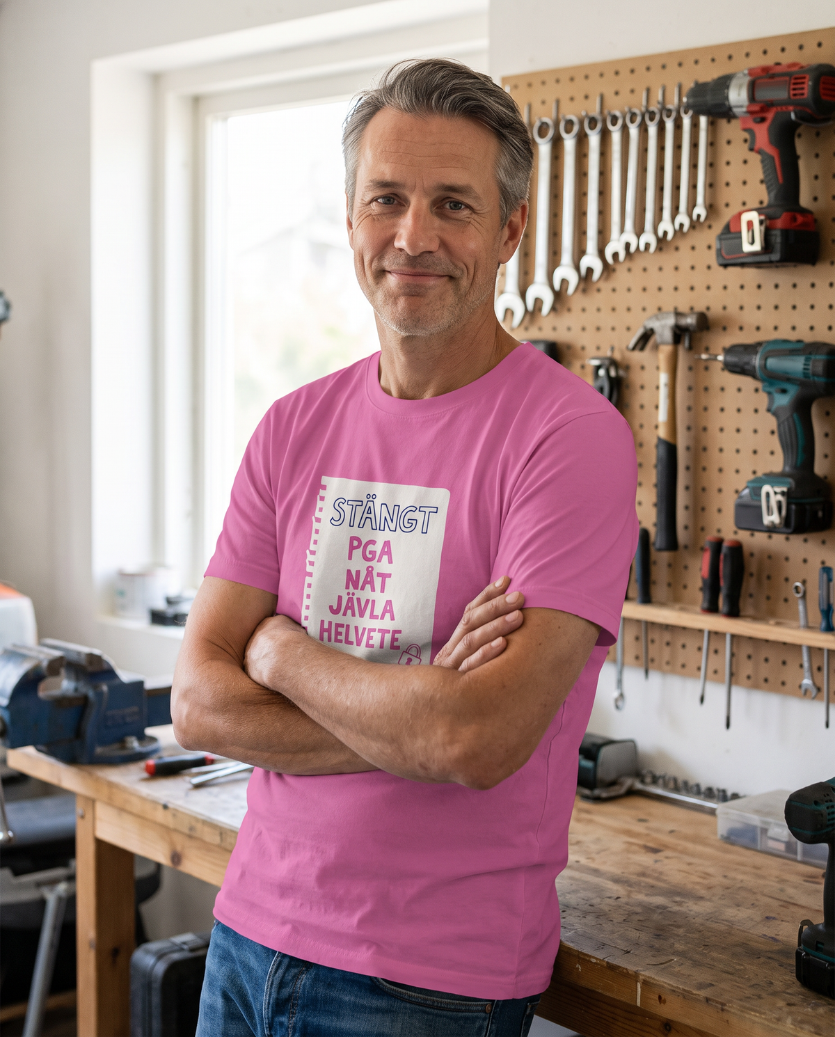 Man i garaget i t-shirt med trycket Stängt pga nåt jävla helvete